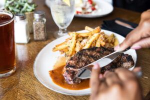 Plated New York Strip Steak being cut into