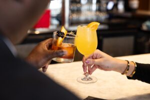 Two cocktails getting clinked together